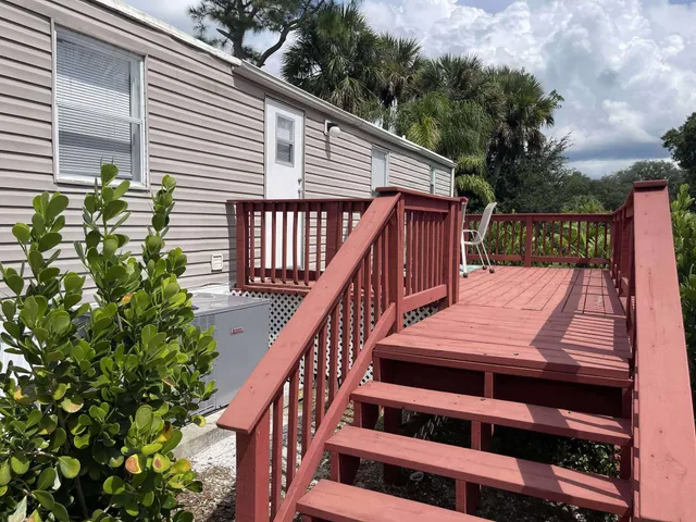 a view of a balcony with wooden floor and fence
