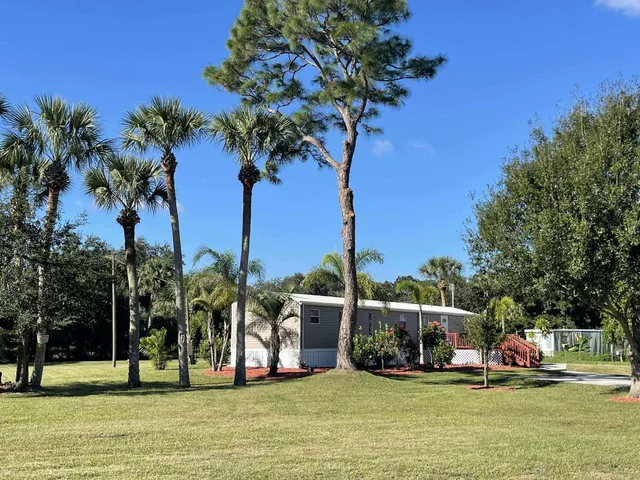 a view of a swimming pool with a bench and trees around