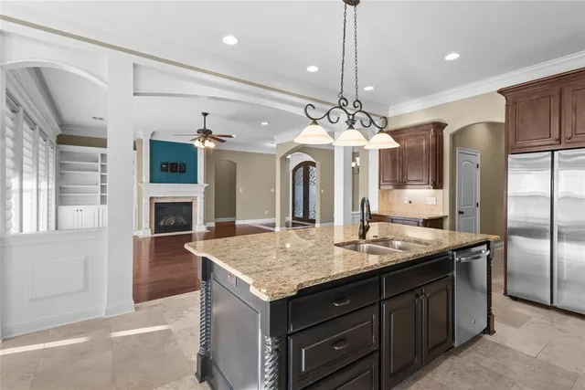 a kitchen with stainless steel appliances granite countertop cabinets a sink a island and windows