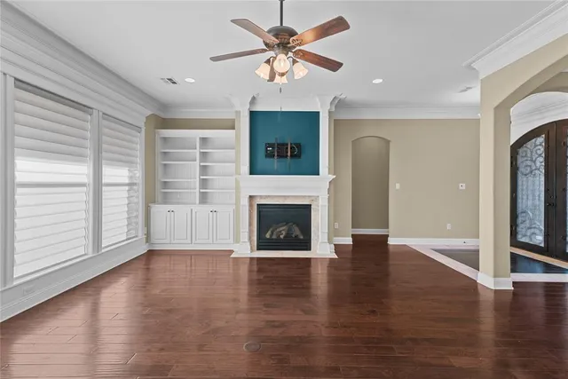 a view of a livingroom with a fireplace a ceiling fan and brick wall