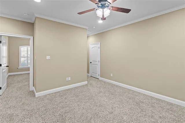 a view of an empty room with a chandelier fan