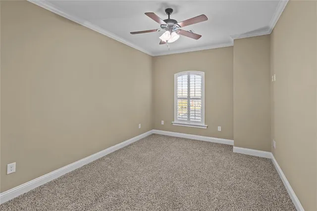 an empty room with windows and ceiling fan