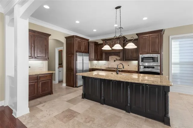 a kitchen with stainless steel appliances granite countertop a sink refrigerator and cabinets