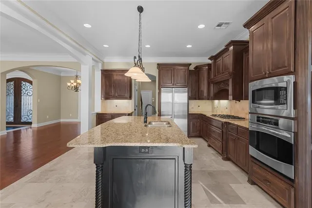 a open kitchen with stainless steel appliances granite countertop a sink a stove and a refrigerator