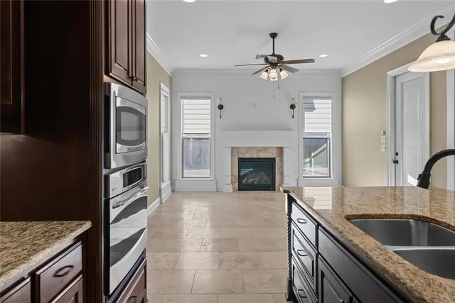 a kitchen with granite countertop a sink stainless steel appliances and chandelier