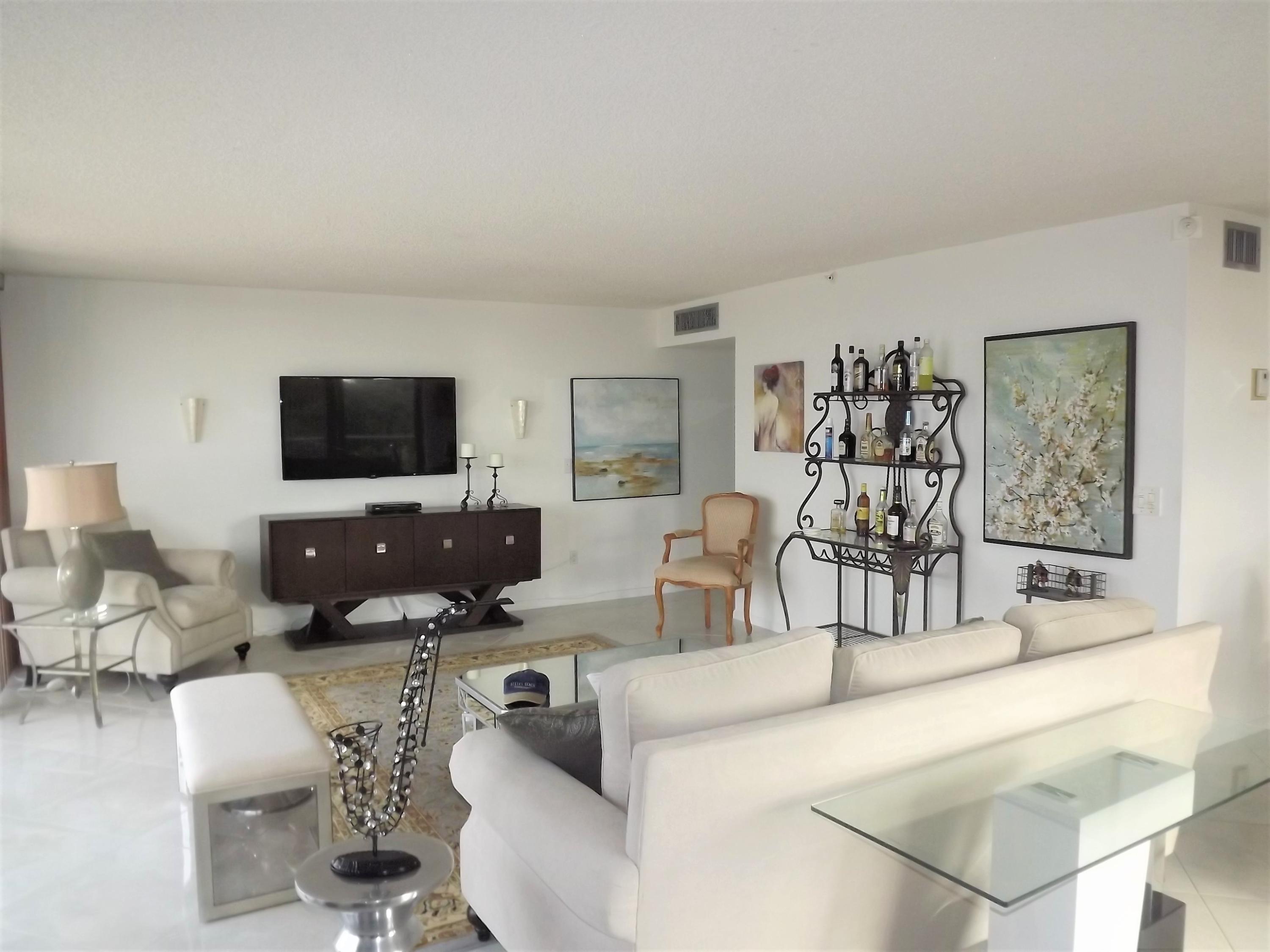 859 Jeffery Street, Unit 702 Boca Raton, FL 33487 - Photo 13 of 40 a living room with furniture a flat screen tv and kitchen view