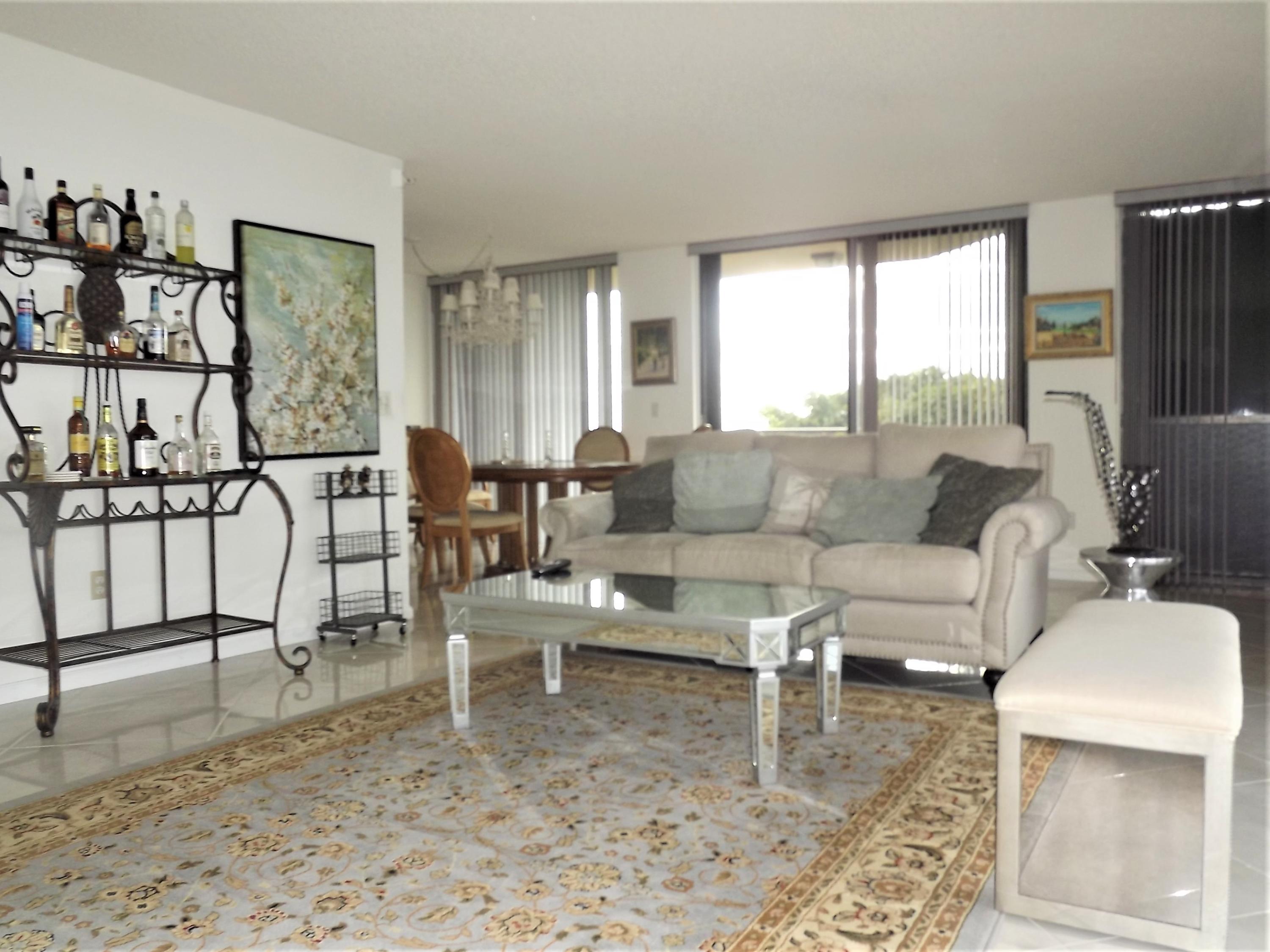 859 Jeffery Street, Unit 702 Boca Raton, FL 33487 - Photo 14 of 40 a living room with furniture wooden floor and a large window