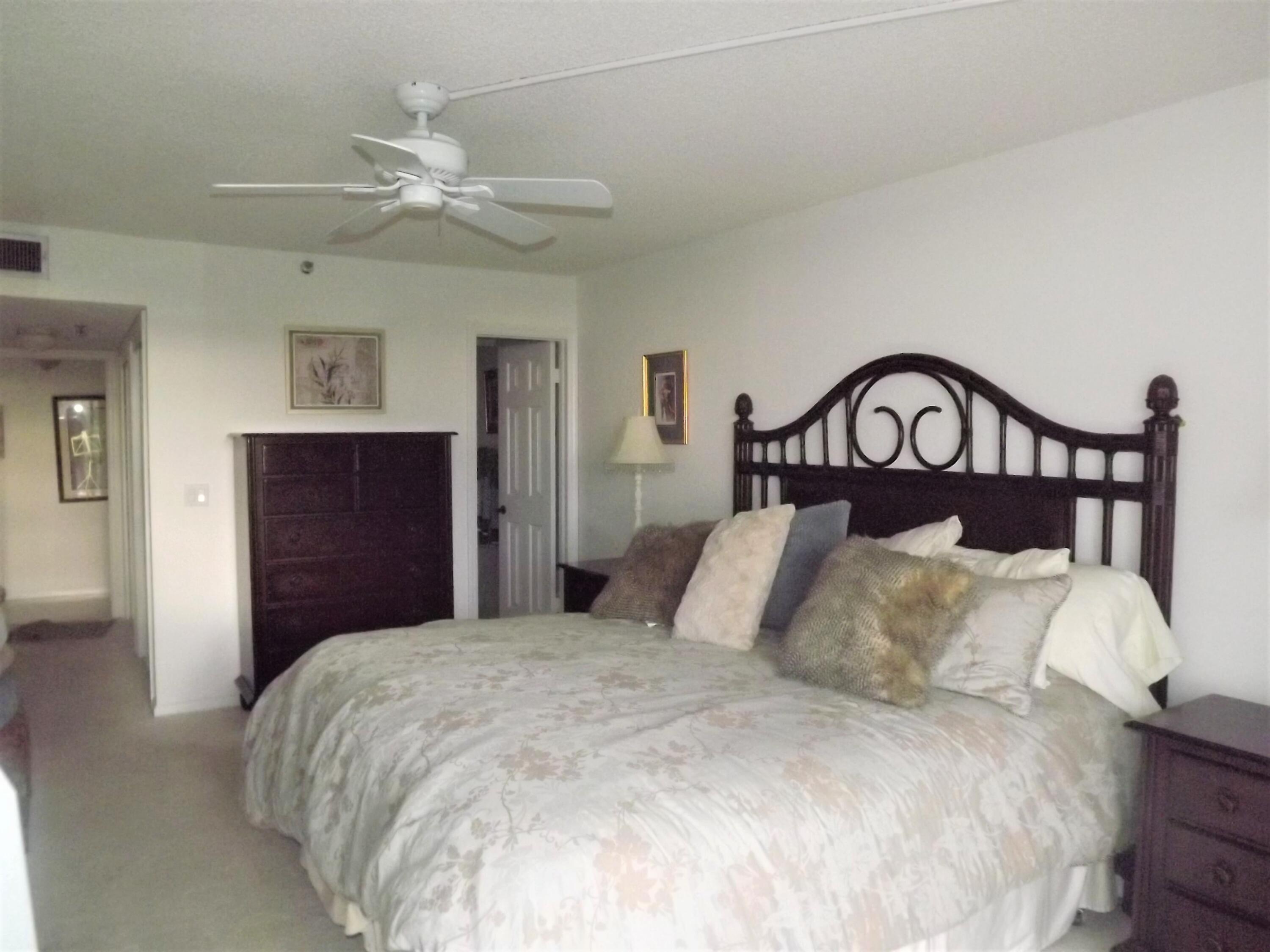 859 Jeffery Street, Unit 702 Boca Raton, FL 33487 - Photo 19 of 40 a bedroom with a large bed and a chandelier