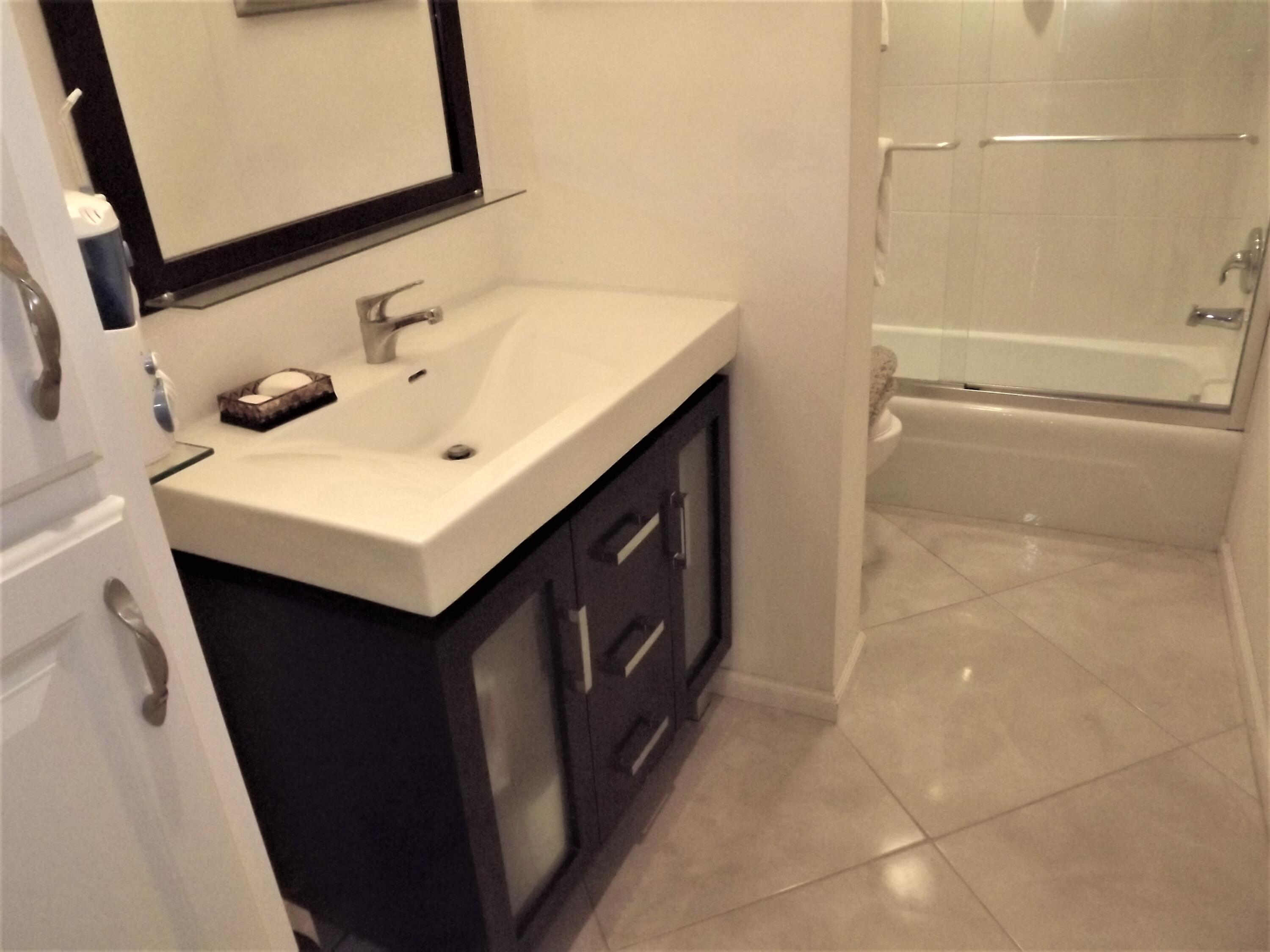 859 Jeffery Street, Unit 702 Boca Raton, FL 33487 - Photo 23 of 40 a bathroom with a sink a mirror and vanity