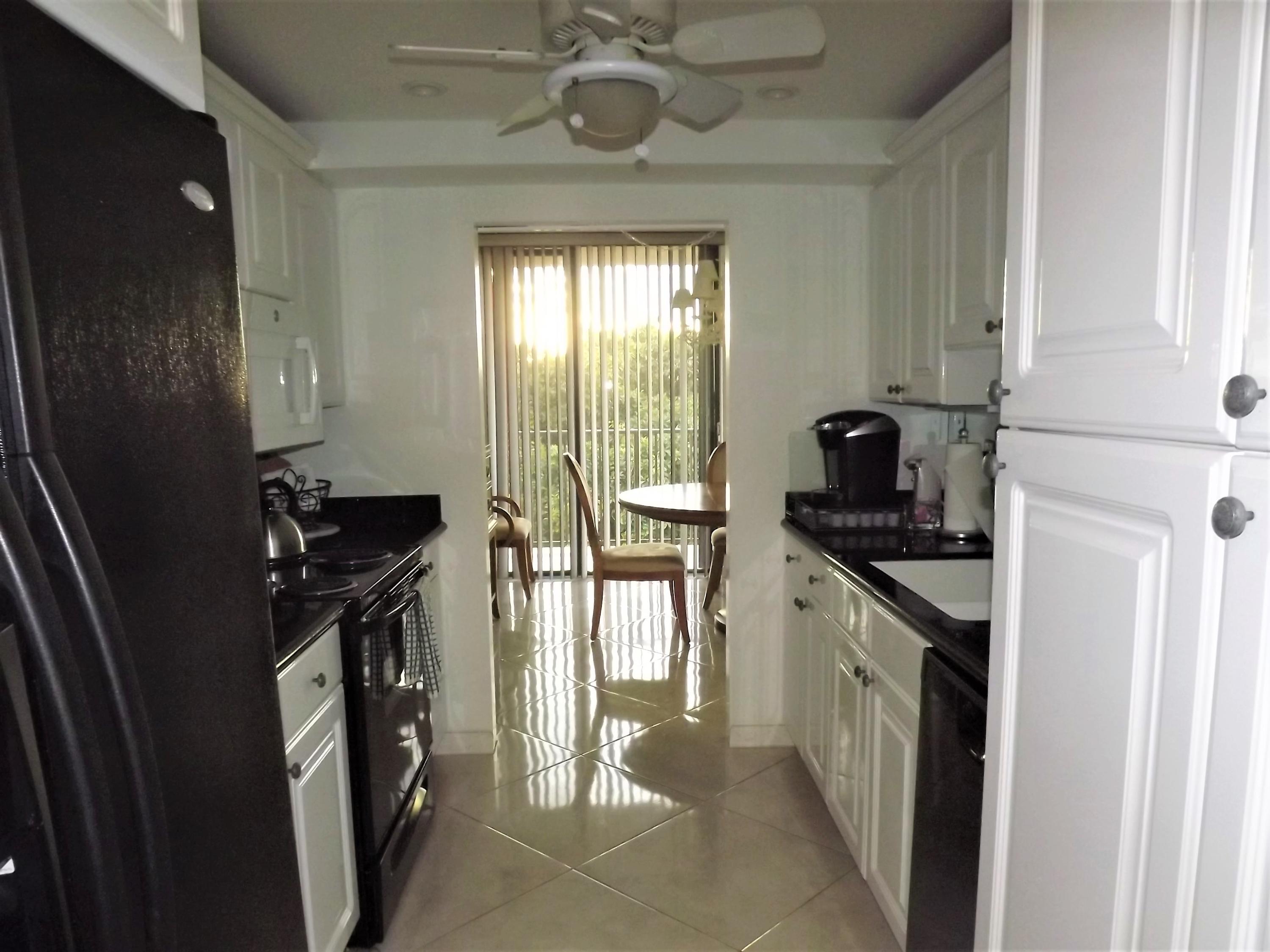 859 Jeffery Street, Unit 702 Boca Raton, FL 33487 - Photo 28 of 40 a kitchen with stainless steel appliances granite countertop a stove a sink and a refrigerator