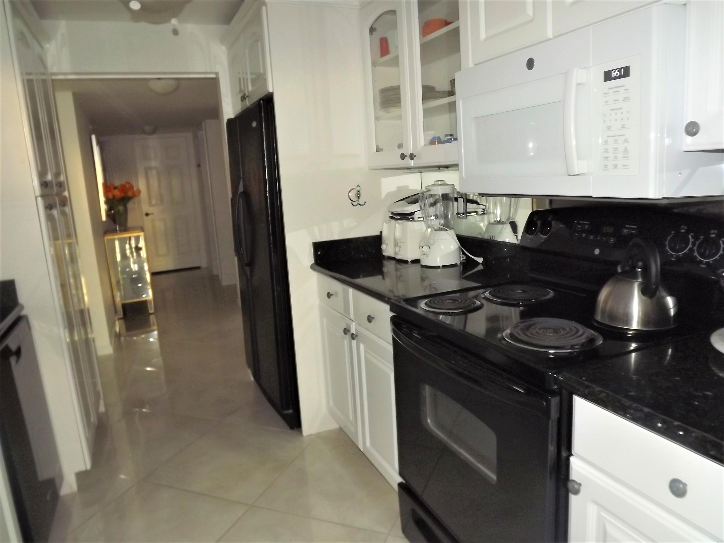 859 Jeffery Street, Unit 702 Boca Raton, FL 33487 - Photo 30 of 40 a kitchen with a sink stove and refrigerator