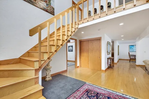a view of entryway and hall with wooden floor