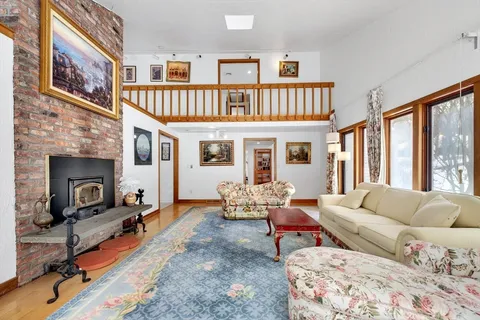 a living room with furniture a fireplace and a large window