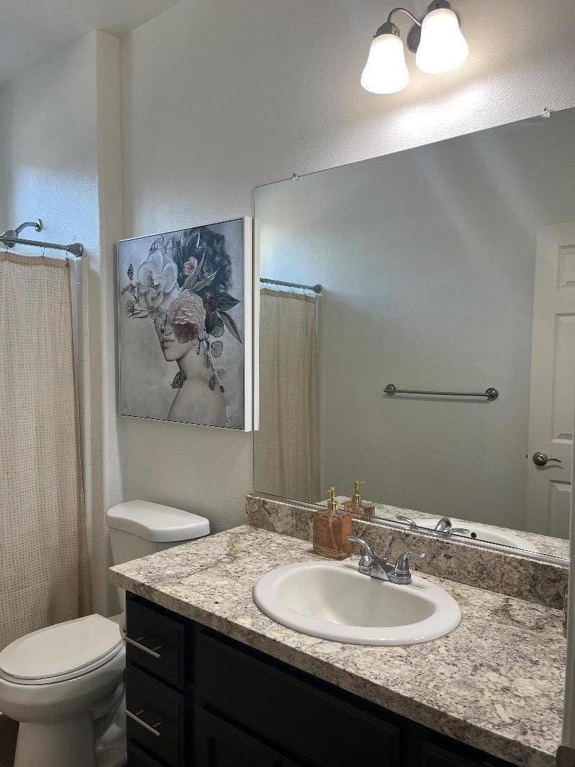 1705 Piazza Drive Salinas, CA 93905 - Photo 12 of 29 a bathroom with a granite countertop sink a toilet and a mirror