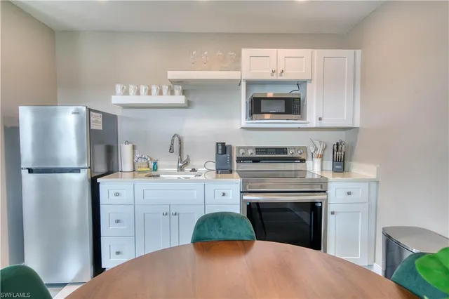 a kitchen with stainless steel appliances a stove refrigerator and cabinets
