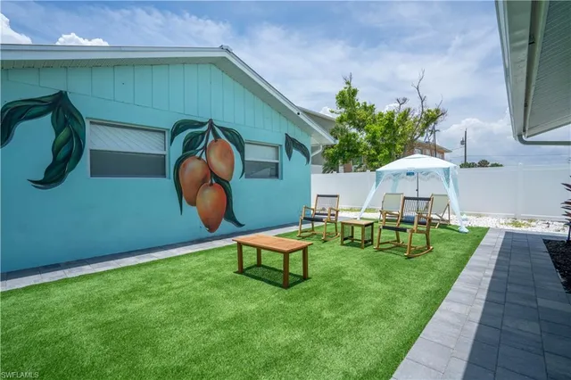 a backyard of a house with table and chairs