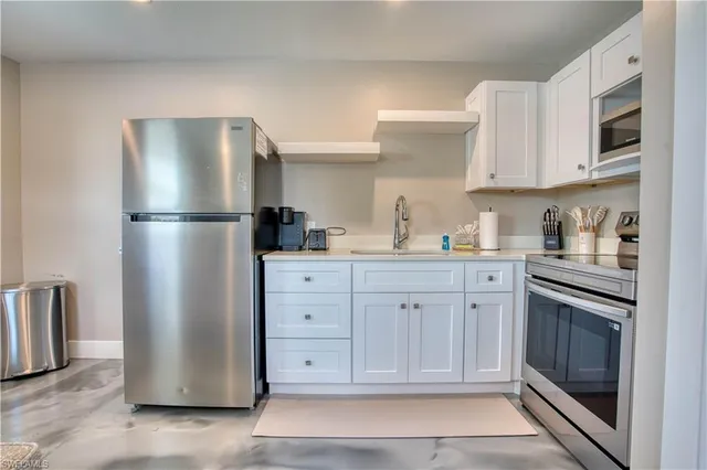 a kitchen with a refrigerator sink and cabinets