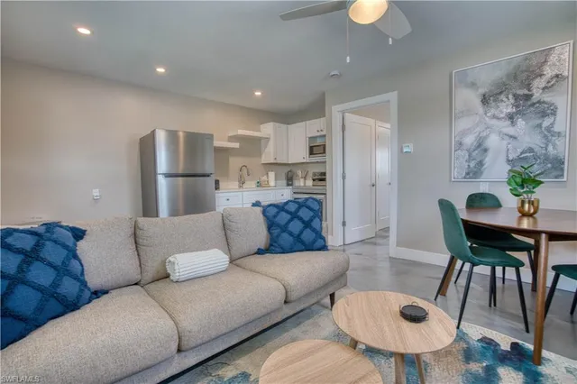 a living room with furniture and a dining table with wooden floor