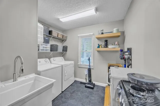 a room with a sink cabinets and appliances