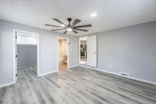 a view of an empty room with wooden floor