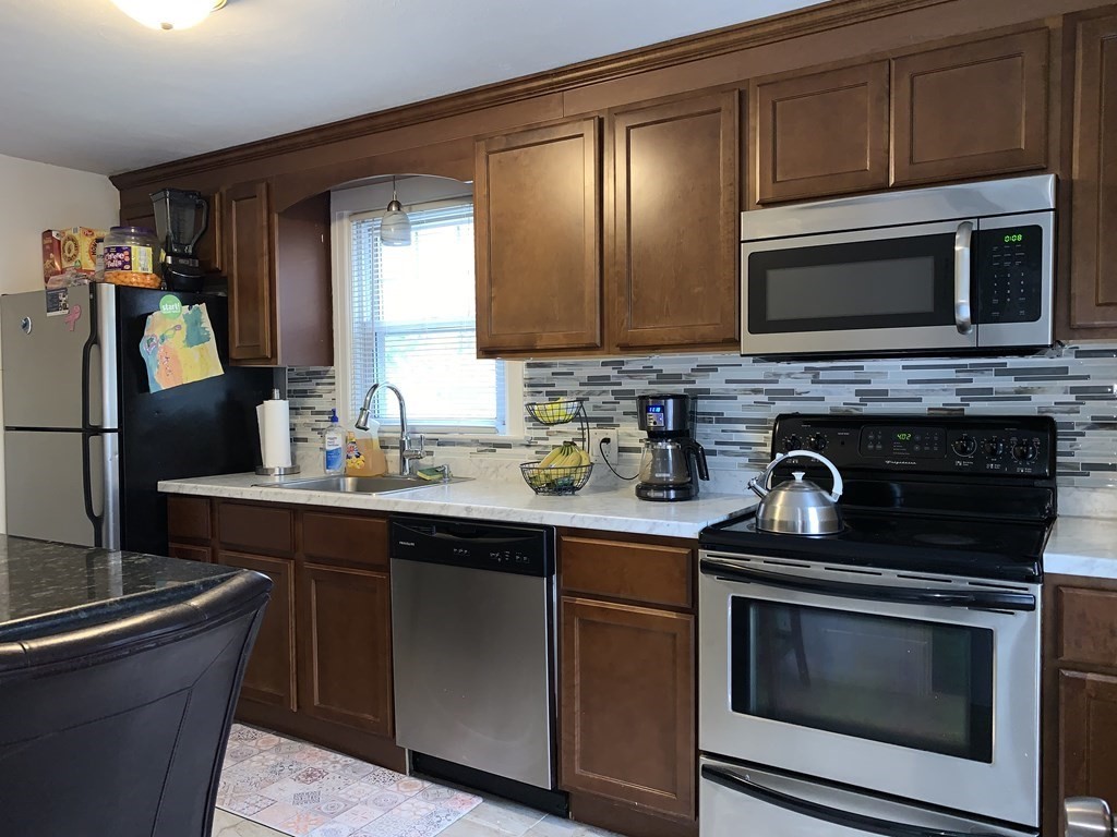 154 Mayflower Road Springfield, MA 01118 - Photo 3 of 15 a kitchen with stainless steel appliances granite countertop a stove microwave and sink