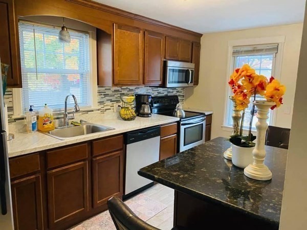 154 Mayflower Road Springfield, MA 01118 - Photo 4 of 15 a kitchen with stainless steel appliances granite countertop a sink dishwasher stove and microwave with wooden floor