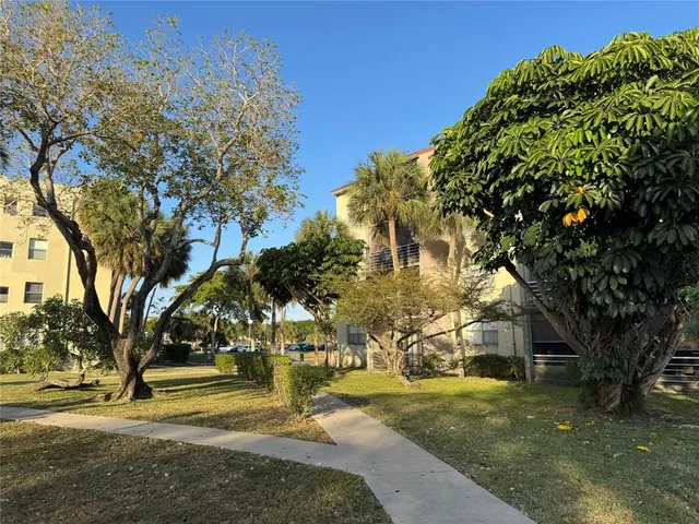 a view of a fountain in front of a house with a big yard
