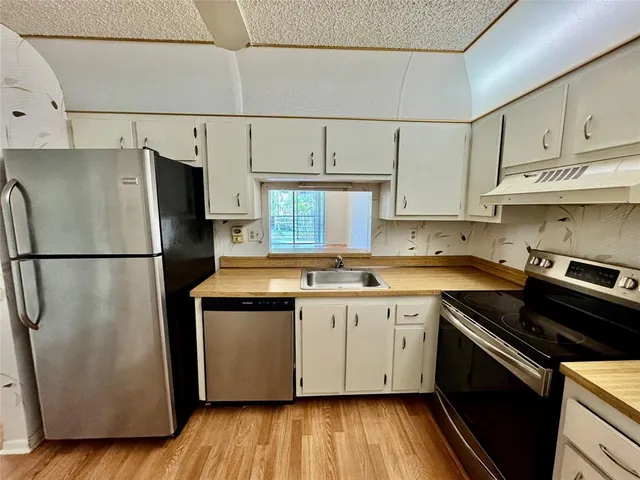 a kitchen with stainless steel appliances granite countertop a sink and cabinets