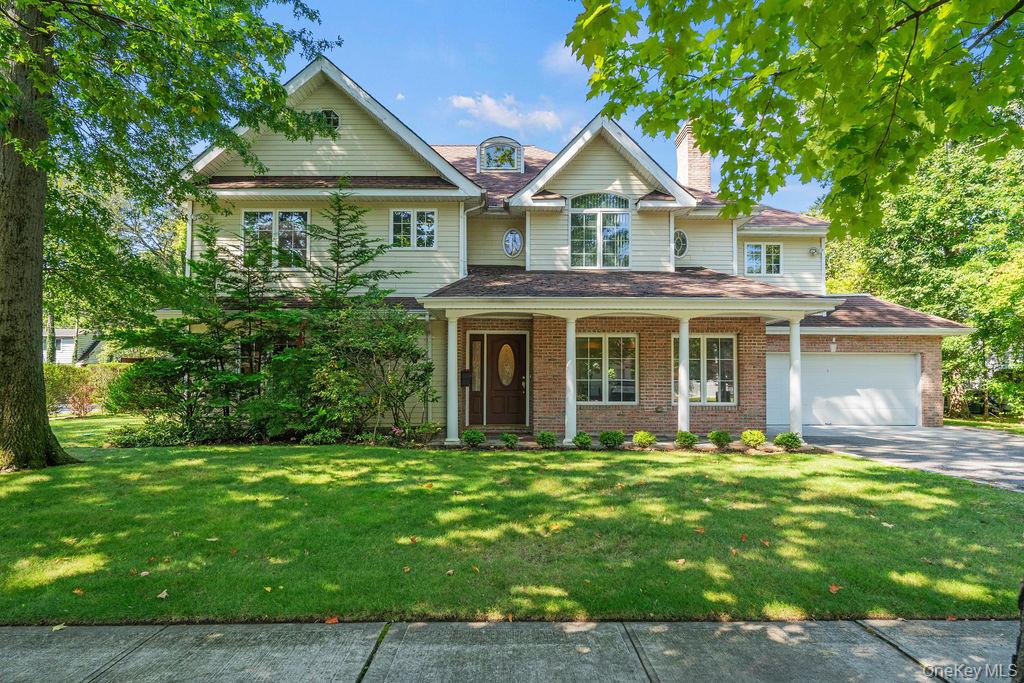 60 Plymouth Road Great Neck, NY 11023 - Photo 2 of 36 View of front of property featuring a porch, a chimney, a front yard, and a garage
