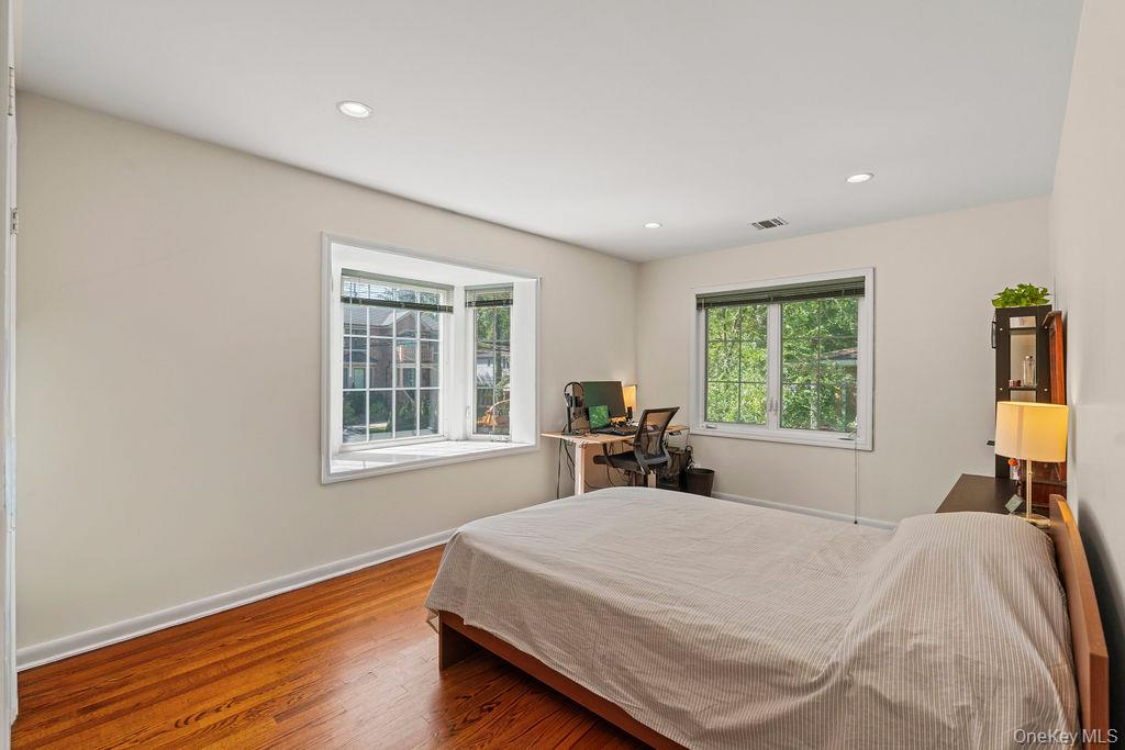 60 Plymouth Road Great Neck, NY 11023 - Photo 22 of 36 Bedroom featuring wood finished floors, multiple windows, a desk, and recessed lighting