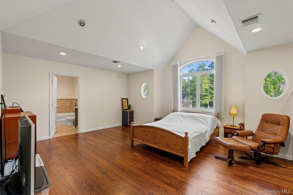 60 Plymouth Road Great Neck, NY 11023 - Photo 24 of 36 Bedroom featuring recessed lighting, wood finished floors, high vaulted ceiling, and connected bathroom