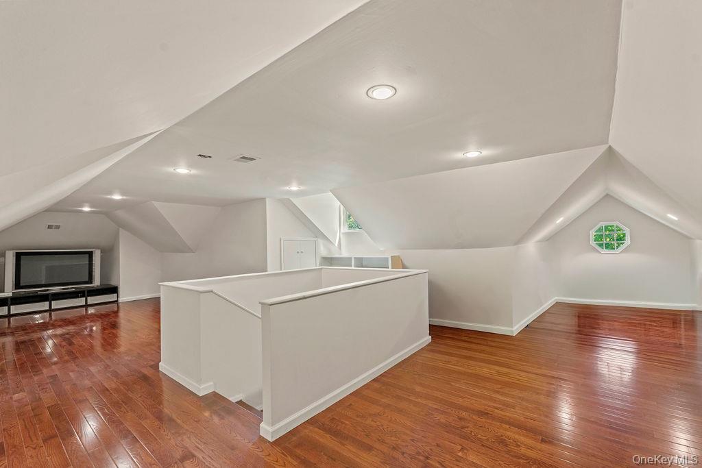 60 Plymouth Road Great Neck, NY 11023 - Photo 30 of 36 Additional living space featuring lofted ceiling and hardwood / wood-style floors