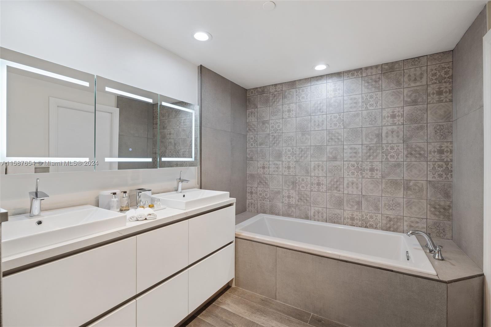 15122 Fisher Island Drive, Unit 15122 Miami Beach, FL 33109 - Photo 21 of 55 a bathroom with a tub a sink and mirror