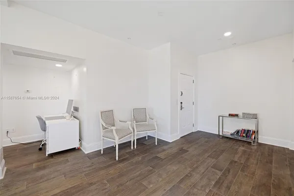 a view of a workspace with furniture and wooden floor