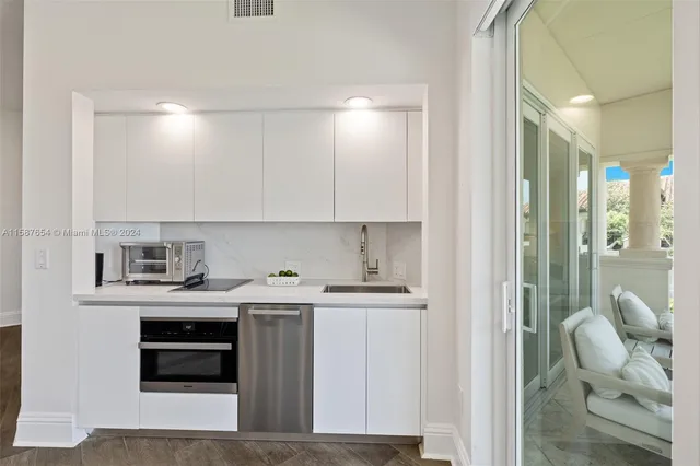 a view of cabinets a sink and a stove top oven