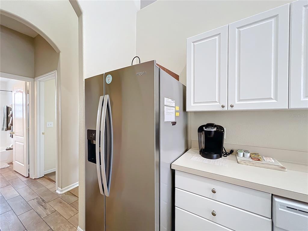 802 Brunello Drive Davenport, FL 33897 - Photo 12 of 36 a kitchen with stainless steel appliances a refrigerator and cabinets