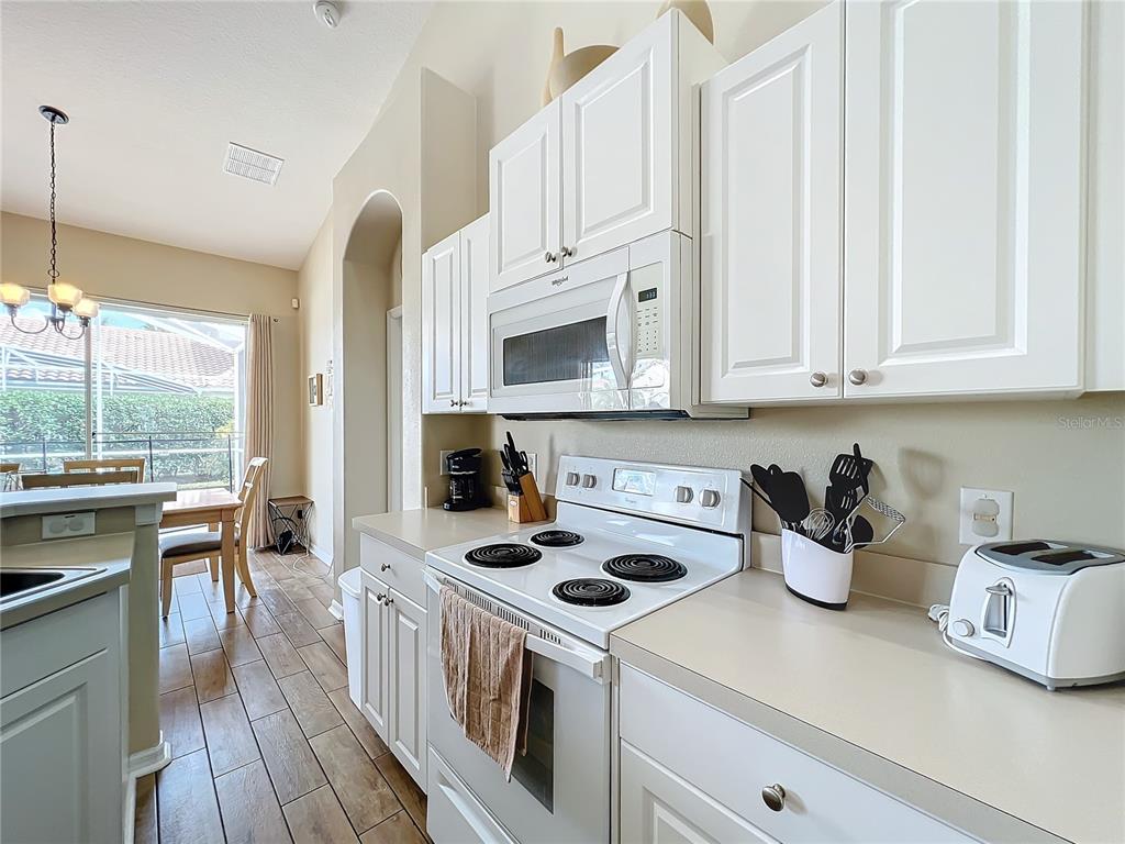 802 Brunello Drive Davenport, FL 33897 - Photo 13 of 36 a kitchen with white cabinets and white appliances