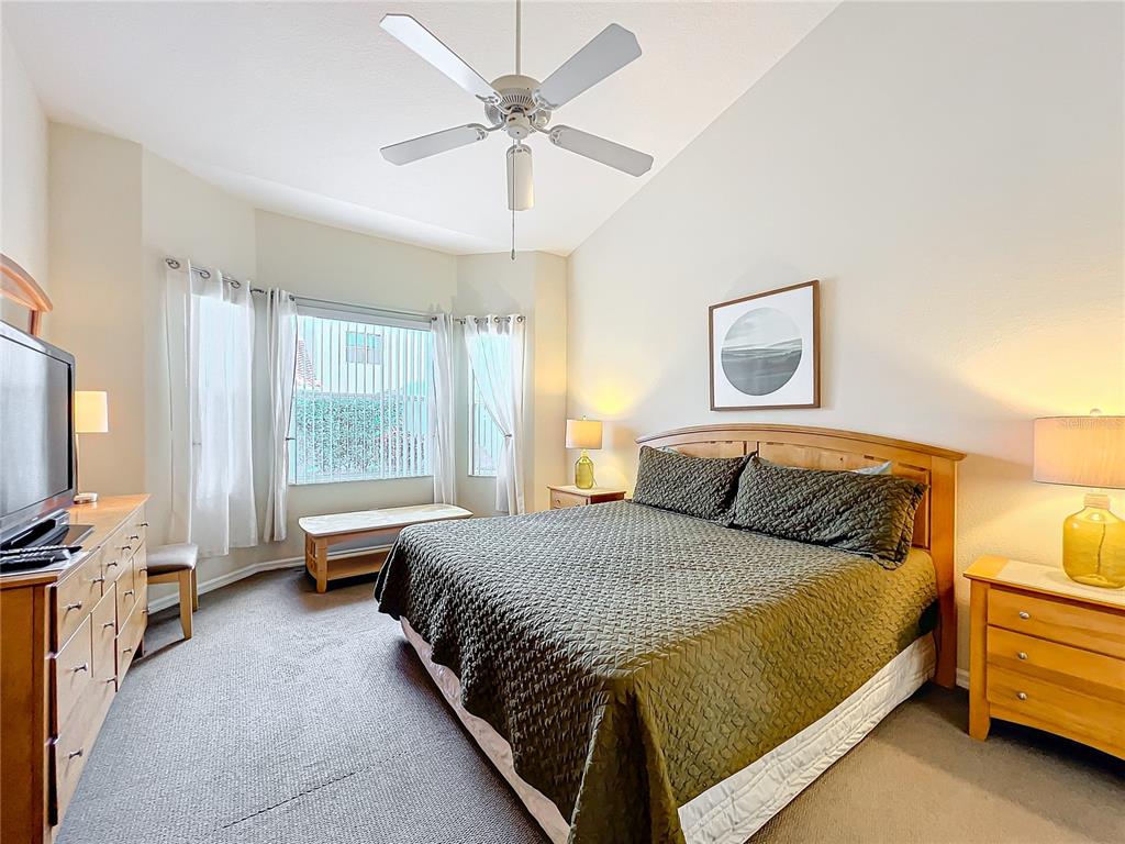 802 Brunello Drive Davenport, FL 33897 - Photo 22 of 36 a bedroom with a bed and a chandelier