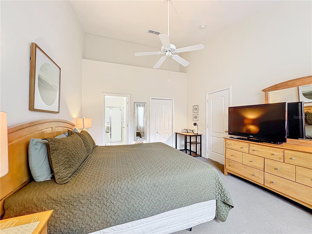 802 Brunello Drive Davenport, FL 33897 - Photo 23 of 36 a bedroom with a bed and a flat screen tv