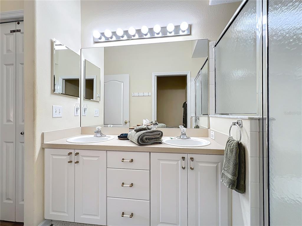 802 Brunello Drive Davenport, FL 33897 - Photo 25 of 36 a bathroom with a double vanity sink and mirror