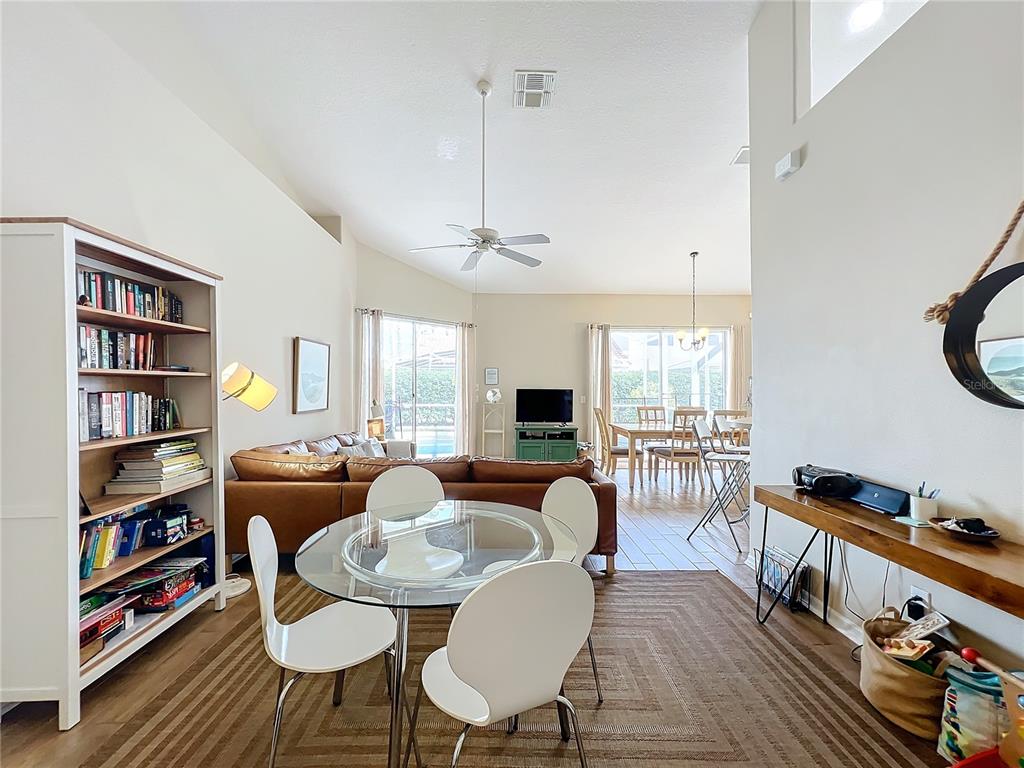 802 Brunello Drive Davenport, FL 33897 - Photo 3 of 36 a living room with furniture a rug and a bookshelf
