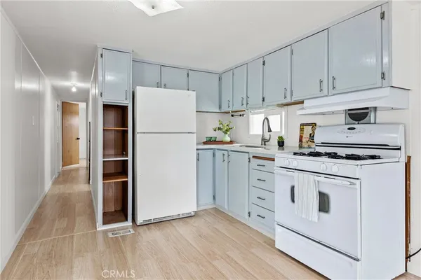 a kitchen with white cabinets and white appliances