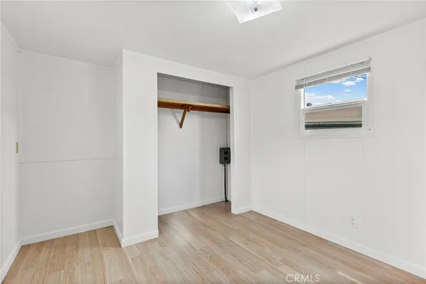 an empty room with wooden floor and a window