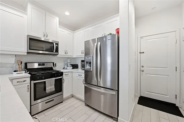 a kitchen with stainless steel appliances a stove a sink and a refrigerator