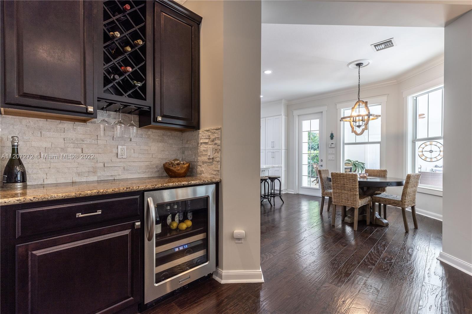 1055 Frederick Small Road Jupiter, FL 33458 - Photo 20 of 48 a kitchen with stainless steel appliances granite countertop a stove top oven a sink dishwasher and a dining table with wooden floor