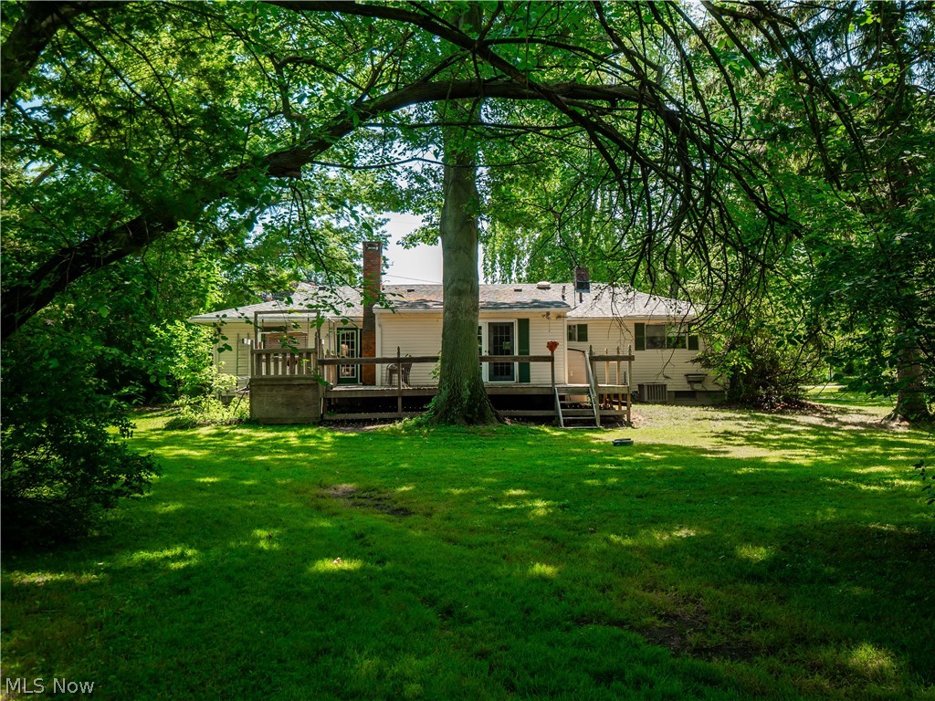 4094 Stoney Ridge Road Avon, OH 44011 - Photo 20 of 36 Back of house featuring a yard and a wooden deck. Located on .83 of an acre.