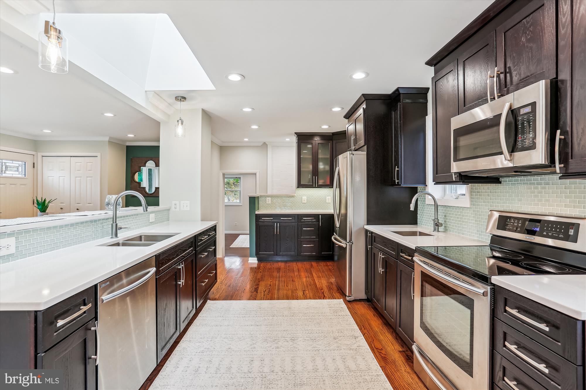 a large kitchen with stainless steel appliances granite countertop a sink stove and refrigerator
