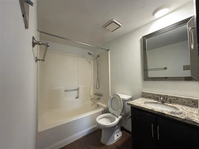a bathroom with a granite countertop sink toilet and shower