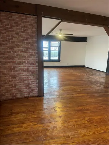 a view of empty room with window and wooden floor