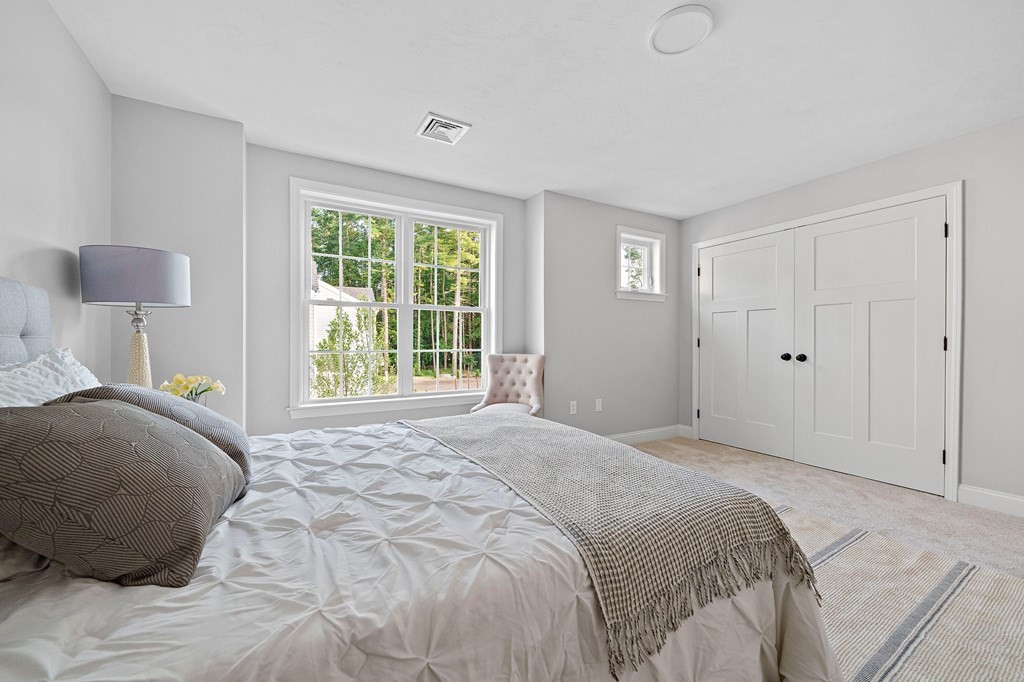 30 Old Washington Street, Unit 9 Pembroke, MA 02359 - Photo 14 of 21 a bedroom with a bed and a lamp